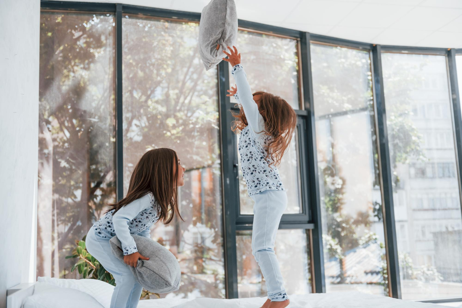with-pillows-hands-two-cute-little-girls-indoors-home-together-children-having-fun